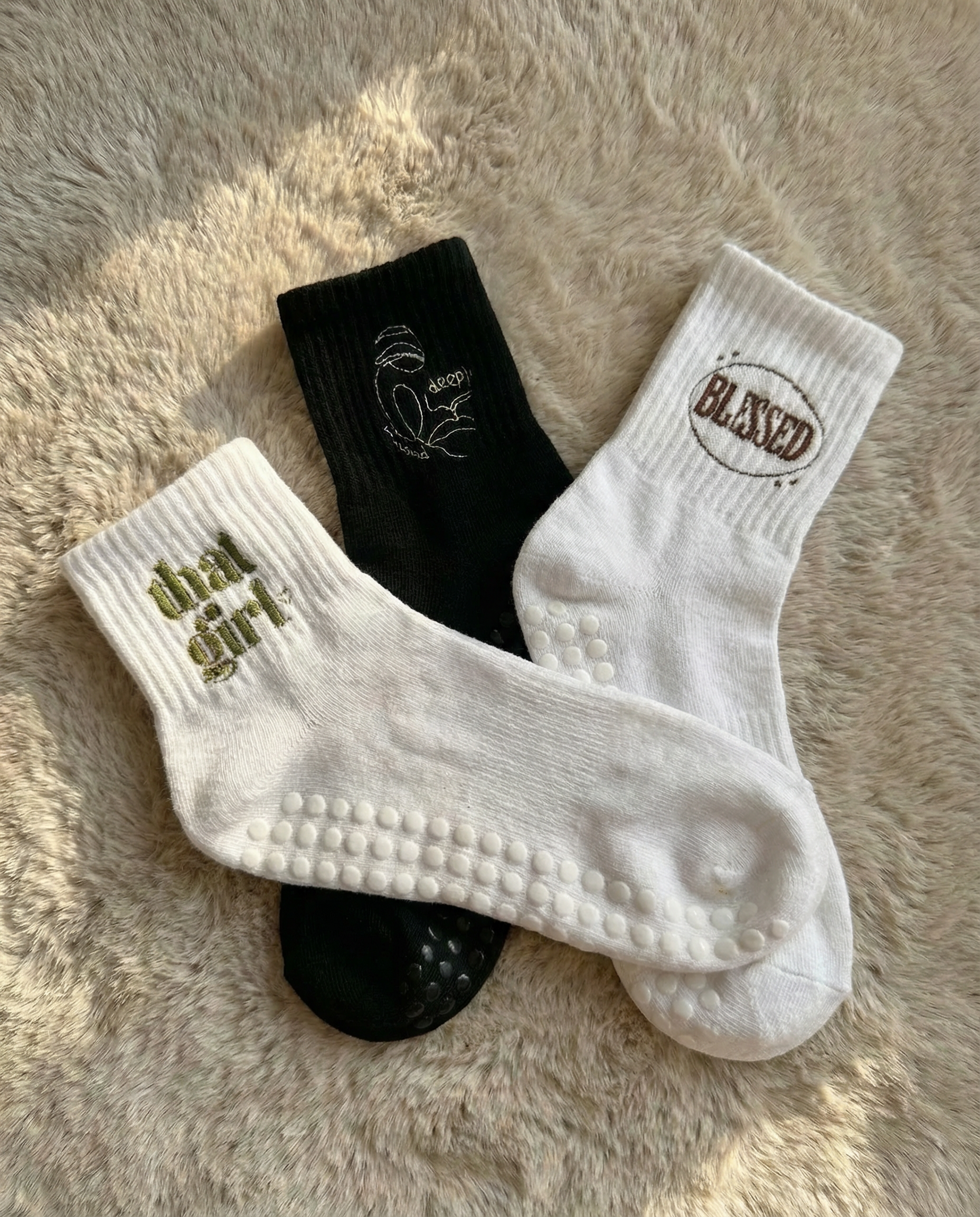 Three pairs of socks with text on a fluffy surface